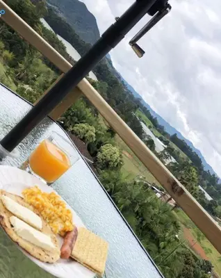 a plate of breakfast food on a table with a view at Alto Paraíso Glamping 