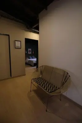 a chair in a room with a room with a bed at Apartamento Centro Comercial los Molinos - ONE203 By Roots Rentals in Medellín