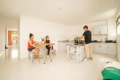 a group of people sitting at a table in a kitchen at Alojamiento Acogedor con excelente ubicacion D in Medellín