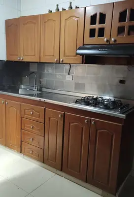 a kitchen with wooden cabinets and a stove top oven at Hab. Cama doble y baño privado #3 in Medellín