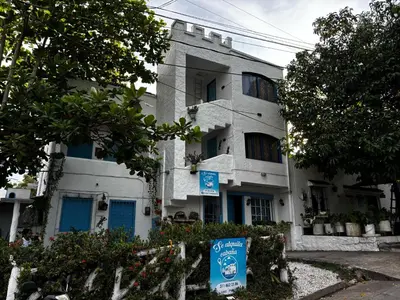 a white building with a sign in front of it at cabaña 83 Santorini in Puerto Triunfo