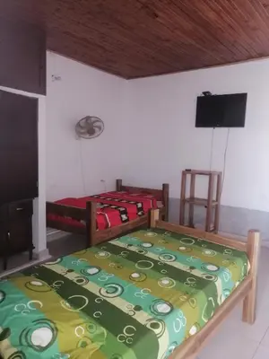 a bedroom with two beds and a flat screen tv at casa de relajación lowcost in La Dorada
