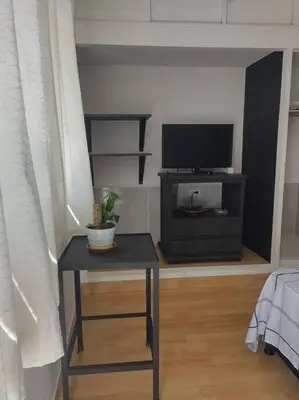 a living room with a table and a television at Acogedor Apartaestudio Santa Fe in Medellín