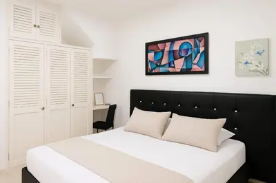 a bedroom with a large bed with a black headboard at Two modern furnished apartments in Medellín