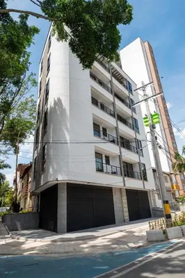 a tall white building on the side of a street at Cozy New Loft in Laureles / Estadio! in Medellín