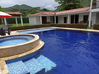 a large blue swimming pool in front of a house at Piscina-jacuzzi-calma-comodidad-Villa Old Havana in Santa Fe de Antioquia