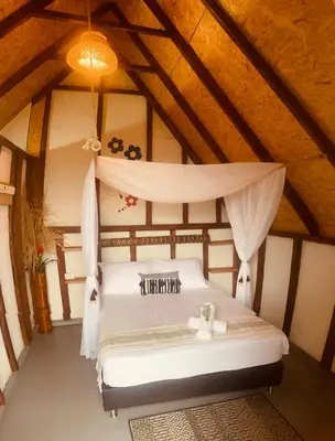 a bedroom with a white bed in a attic at Cabañas Villa Loe in Jardin