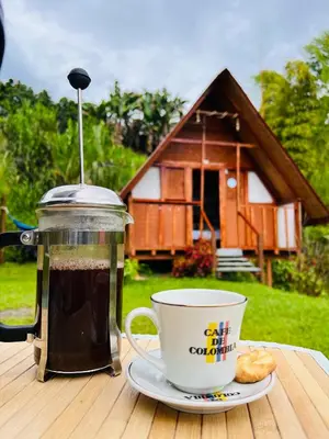 a cup of coffee on a table next to a coffee at Cabañas Villa Loe in Jardin
