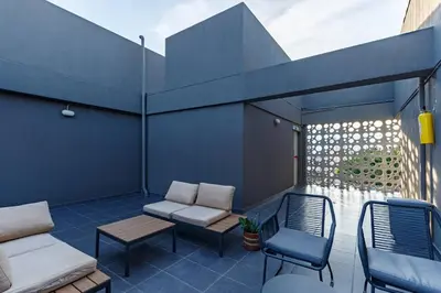a patio with chairs and a couch and a table at Apartamento Tranvía 210 in Medellín