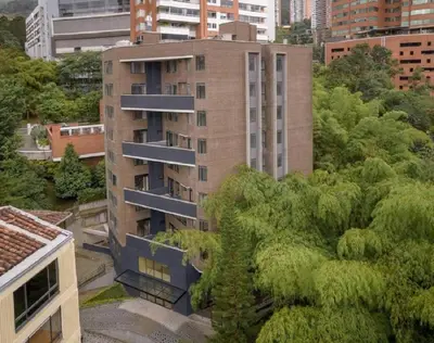 a tall building with trees in front of it at El Tesoro Medellín Hab309 by Letoh in Medellín