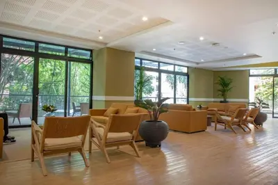 a waiting room with chairs and tables and windows at El Tesoro Medellín Hab311 by Letoh in Medellín
