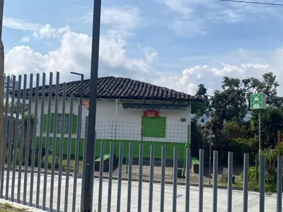 a white building with a green door behind a fence at LA CASA DEL CABLE - Hermoso Apartamento - in Manizales