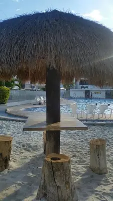 a table with a straw umbrella on the beach at SANTAFE APARTASOLES in Santa Fe de Antioquia