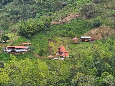 a group of houses on a hill with trees at Cabaña Los Colibríes in San Rafael