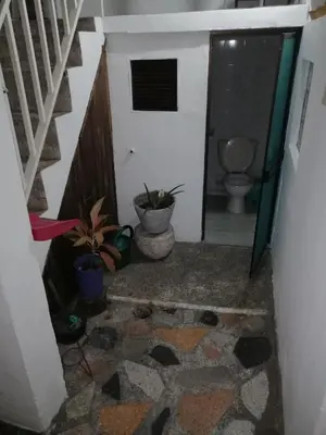 a hallway with a bathroom with a toilet and plants at Casa de relajación low cost in La Dorada