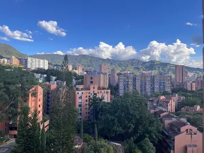 a city with buildings and mountains in the background at El Poblado acomodación familiar hasta 6 personas in Medellín