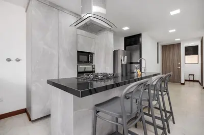 a kitchen with a counter with stools and a stove at MEDELLIN- Cerca al Poblado - 301 in Medellín