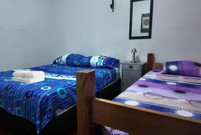 a bedroom with two beds and a mirror at Casa Rio y Montaña in Honda
