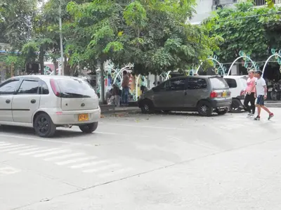 two cars parked in a parking lot with people walking at Central y privado a 1km de la hacienda Nápoles in Doradal