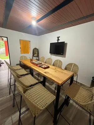 a wooden table with chairs and a tv on a wall at Las 5 Quintas - Acogedora casa in San Rafael
