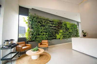 a room with a green wall with a table and chairs at TOP FLOOR Studio Poblado, A/C, Coworking, gym 1416 in Medellín