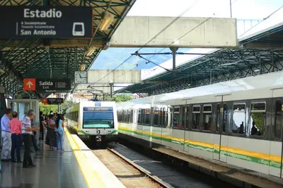 two trains at a train station with people waiting on the platform at E2P RENOVADO y BELLO APARTAMENTO EN LAURELES ESTADiO in Medellín