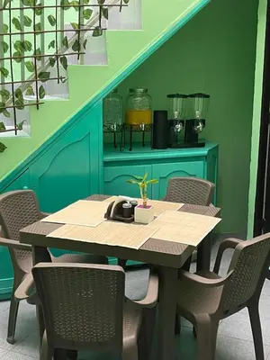 a dining room table with chairs and a green wall at Hotel San Pablo boutique H9 in Medellín
