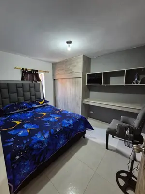 a bedroom with a bed and a desk and a chair at ECXEPCIONAL y ELEGANTE APARTAMENTO in Medellín