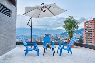 a patio with chairs and a table and an umbrella at The place you need in Poblado-Medellin 1103 in Medellín