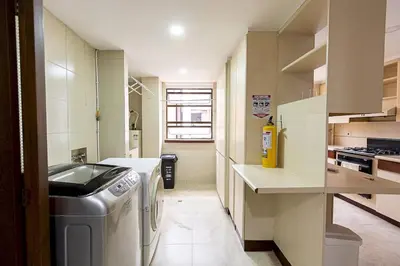 a small kitchen with a washing machine in it at Bello alojamiento baño compartido en el Poblado-A5 in Medellín