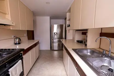 a kitchen with a sink and a stainless steel refrigerator at Bello alojamiento baño compartido en el Poblado-A5 in Medellín