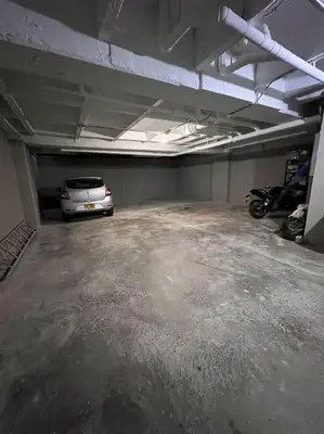 a parking garage with a car parked in it at Apartamento centrico en Laureles con piscina 301 in Medellín