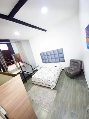 a living room with a bed and a chair at Urban 8 Bedrooms Apartment at Poblado in Medellín