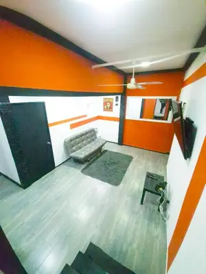 a living room with a couch and orange walls at Sunset Strip Suite # 301C ICON Lleras Park 301 in Medellín