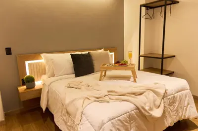 a bedroom with a bed with a table on it at Cozy Aparta-Suite Stadio Jacuzzi Rosa Negra in Medellín
