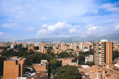 a view of a city with buildings and mountains at Rosa Negra Haven Cozy Stadio Aparta-Suite in Medellín