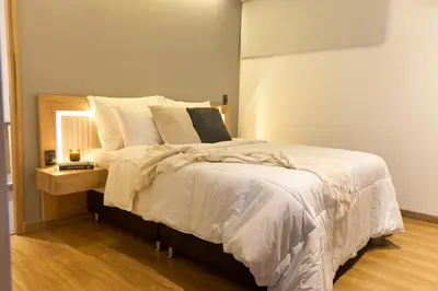 a bedroom with a large bed with white sheets and pillows at Comfortable Stadio Suite Rosa Negra in Medellín