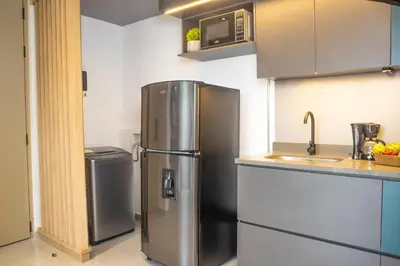 a kitchen with a stainless steel refrigerator and a sink at Rosa Negra Comfort Stadio Aparta-Suite in Medellín