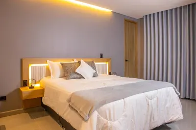 a bedroom with a large white bed with pillows at Stadio Serenity Rosa Negra Aparta-Suite in Medellín
