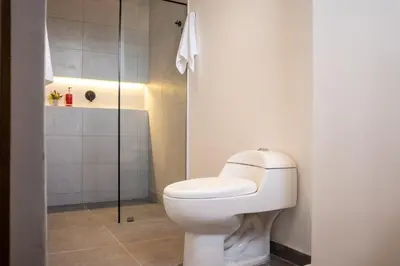 a bathroom with a toilet and a shower at Stadio Serenity Rosa Negra Aparta-Suite in Medellín