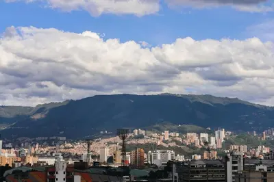 a view of a city with mountains in the background at Cozy Comfort at Rosa Negra Stadio Suite in Medellín