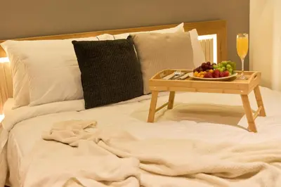 a table with a bowl of fruit on a bed at Rosa Negra Suite Near Stadium in Medellín