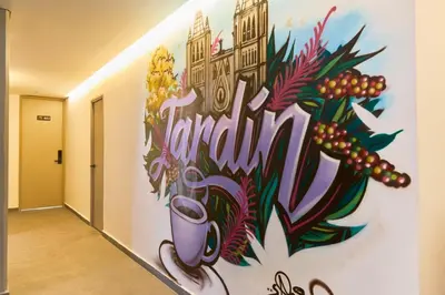 a wall in a hallway with a painting on it at Rosa Negra Suite Near Stadium in Medellín