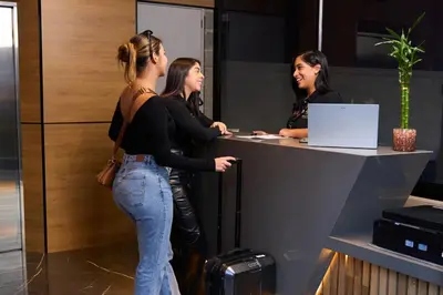 three women standing at a counter in an office at Rosa Negra Suite Near Stadium in Medellín
