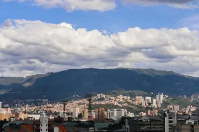 a view of a city with mountains in the background at Comfortable Escape | Rosa Negra Stadio ApartaSuite in Medellín
