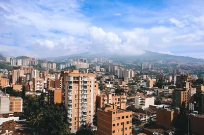 a city with buildings and a mountain in the background at Comfortable Escape | Rosa Negra Stadio ApartaSuite in Medellín
