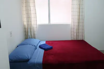 a bed in a room with a large window at Living Poblado Manila 3028 Habitación Doble in Medellín