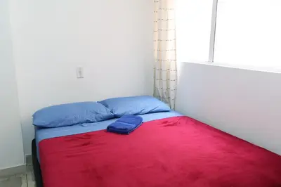 a bed in a room with a red and blue blanket at Living Poblado Manila 3028 Habitación Doble in Medellín