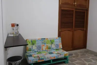 a couch with a quilt sitting in front of a door at Living Poblado Manila 3026 Habitación Individual in Medellín