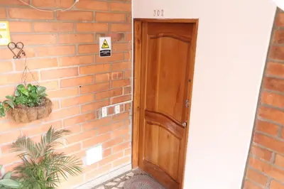 a wooden door next to a brick wall at Living Poblado Manila 3027 Habitación Individual in Medellín